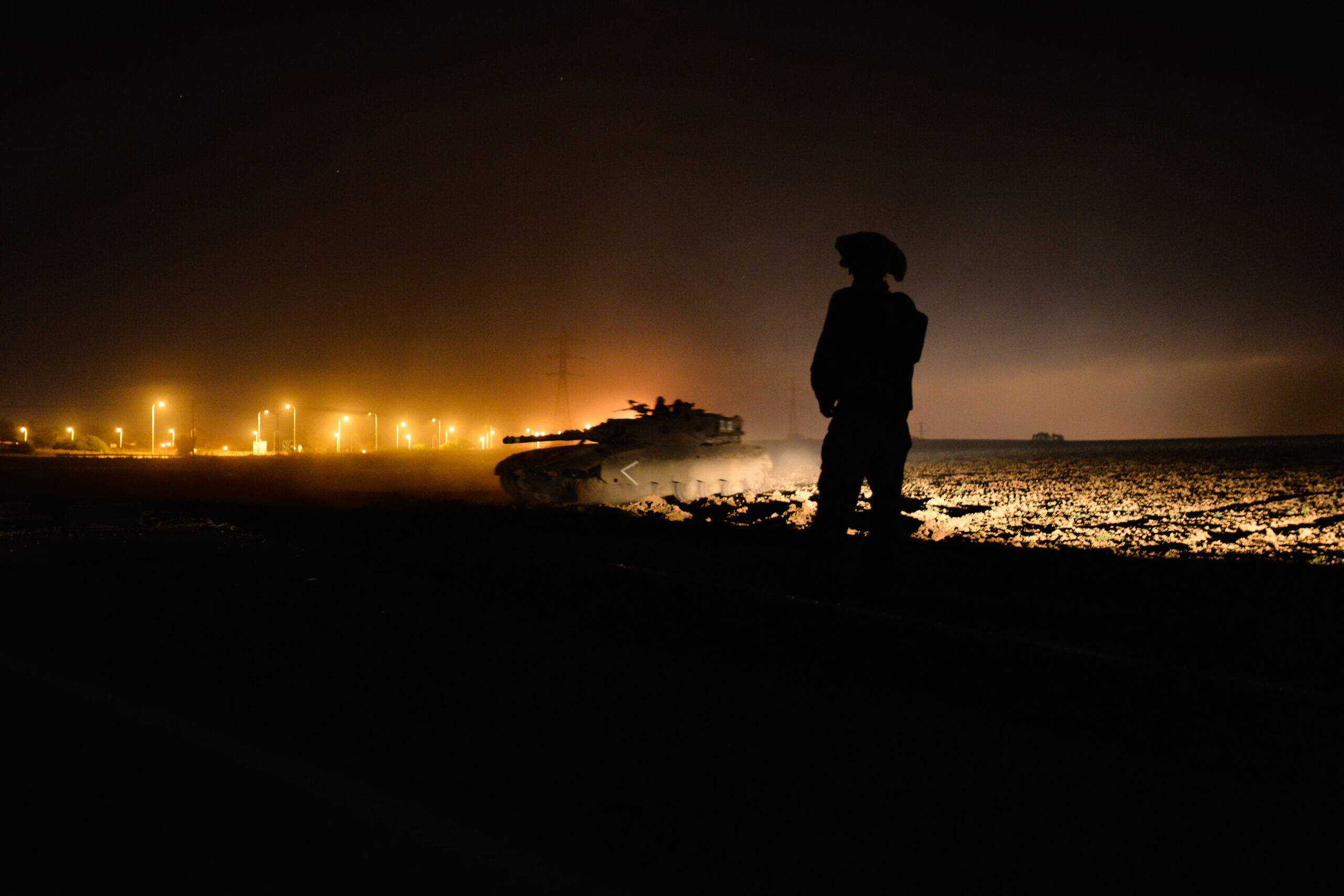 Israeli soldiers walking together, one carrying an Israeli flag